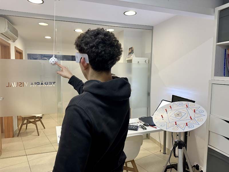 Chico realizando ejercicio  terapia visual  con una bola